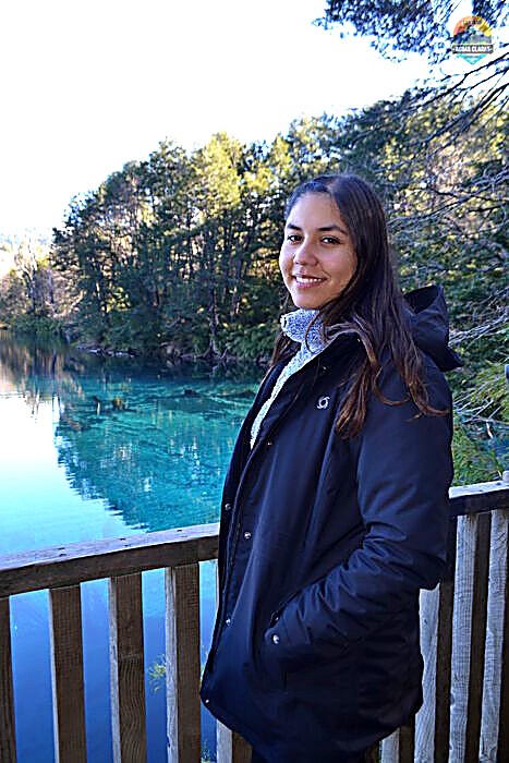 Visitante junto a una laguna de aguas turquesa en el Parque Nacional Conguillío