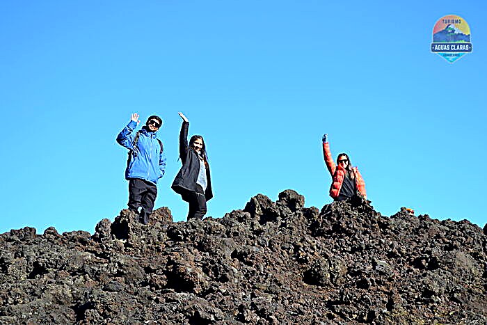 Visitantes sobre roca volcánica en el Parque Nacional Conguillío