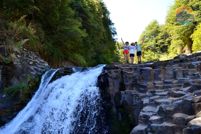 Familia sobre las columnas basálticas de la cascada Garganta del Brujo, en el Geoparque Kütralkura