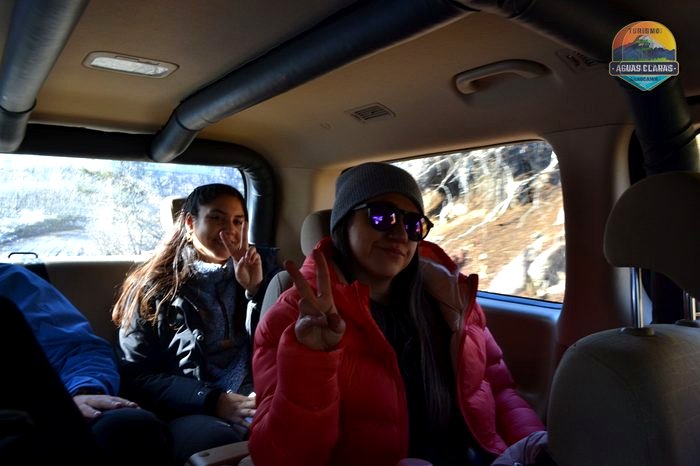 Pasajeras del tour dentro del furgón, con la cordillera nevada de fondo