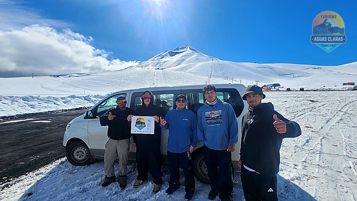 Grupo junto al furgón de Aguas Claras frente al volcán Lonquimay nevado, en el centro de ski Corralco